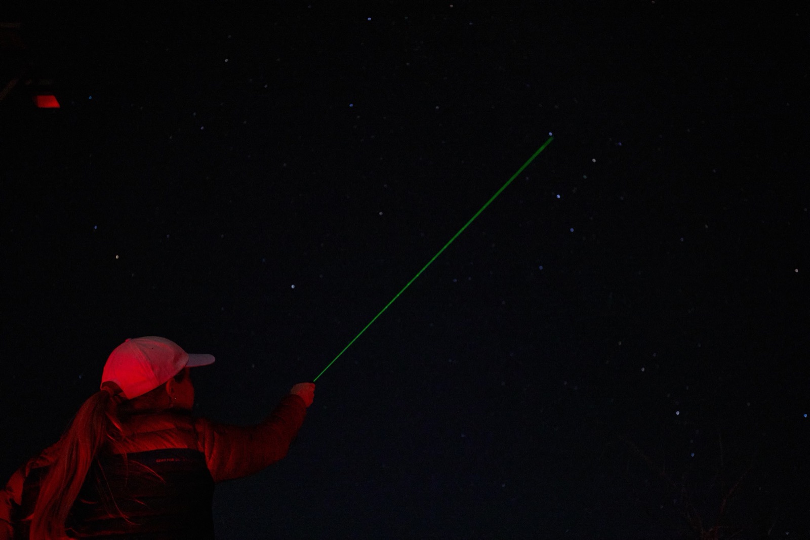 Bryce Canyon Stargazing guide pointing a green laser at the night sky to identify targets for a tour group